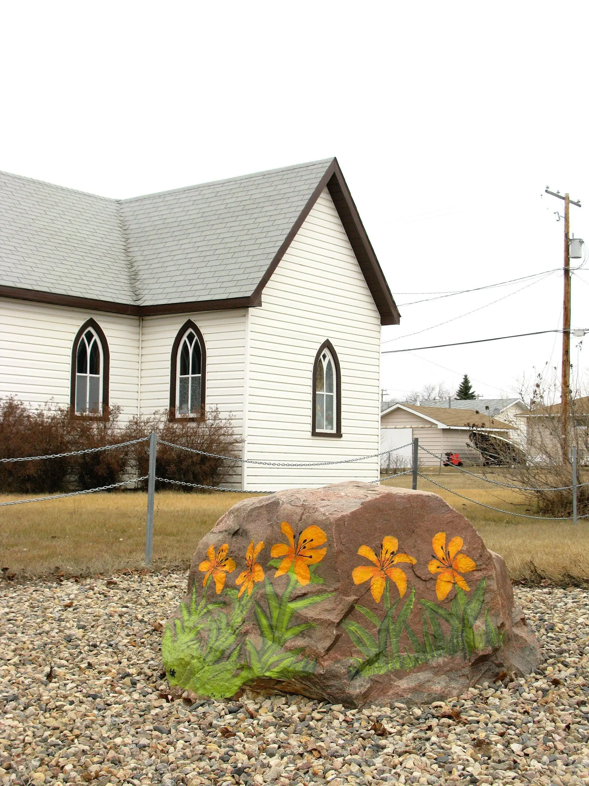 Painted lily rock in front of a small church