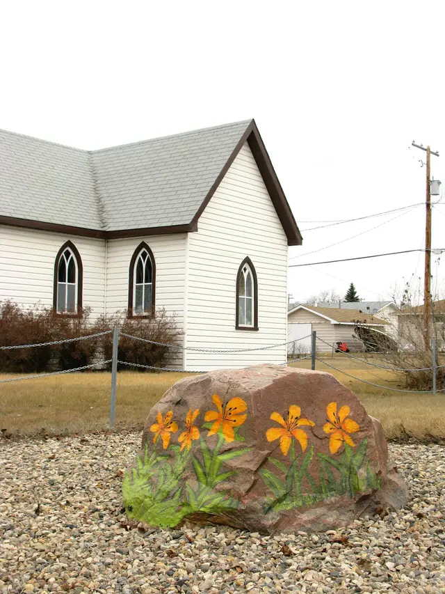 Painted lily rock in front of a small church